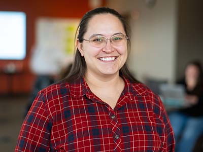 Smiling friendly early 30s woman wearing red plaid shirt