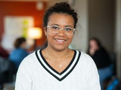 TAP alum Lane S. wearing glasses and white sweater with blue vneck 